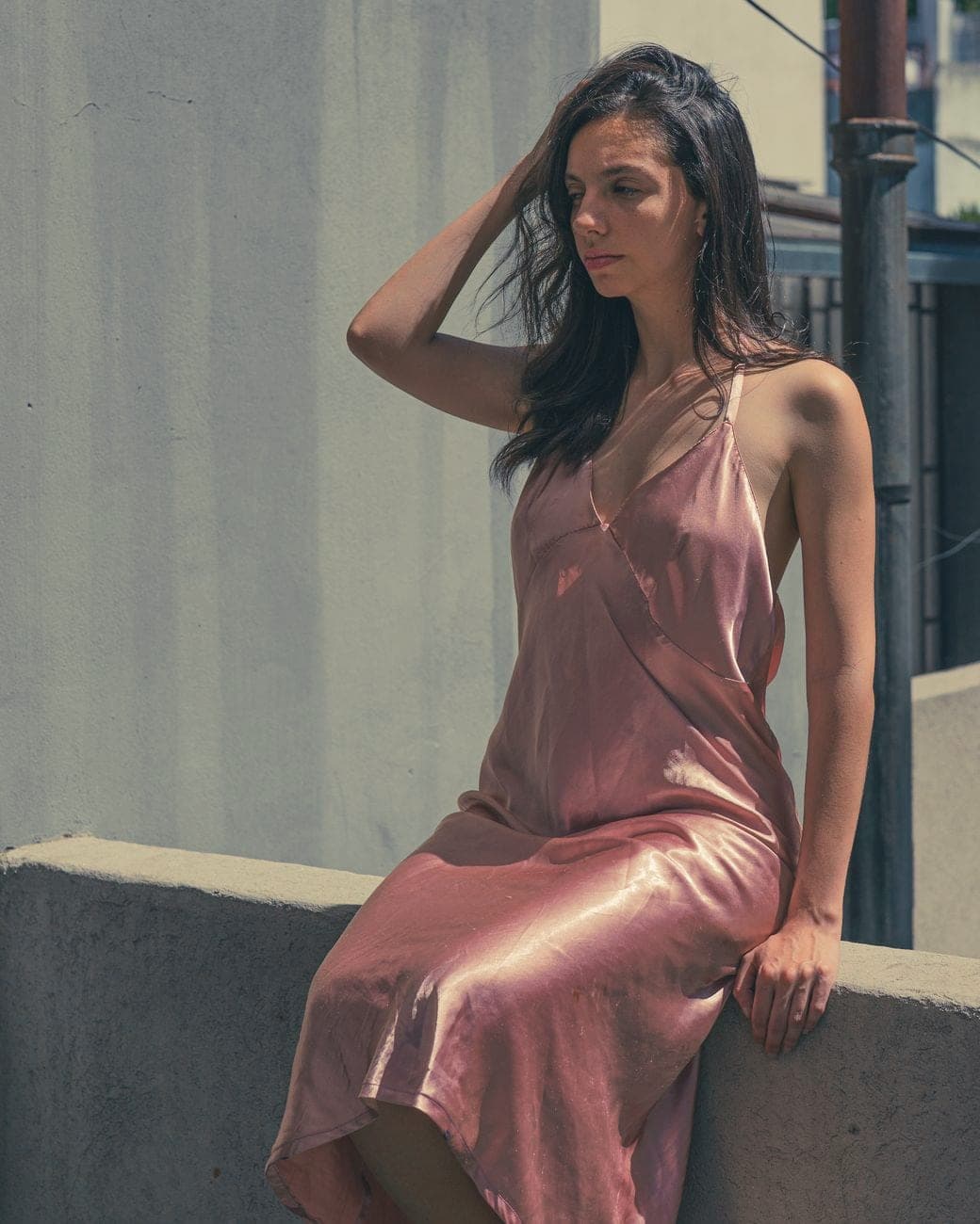 Vrouw in een roze satijnen slipdress met spaghettibandjes